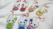 Load image into Gallery viewer, Closeup of all fruit bunny acrylic charms on white blanket.