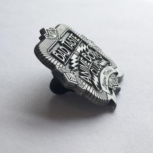 Side view of bad taste antique silver pin on white background.