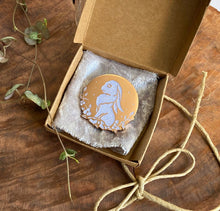 Load image into Gallery viewer, Moon Rabbit pin in brown jewelry box with white cloth. 