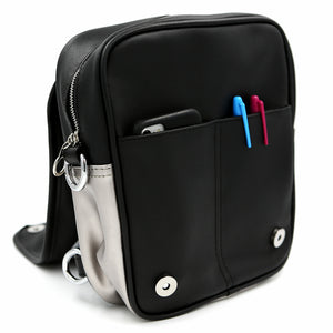 Open view of Moon Ita bag  with phone and two sharpies tucked in each of its two front pockets.