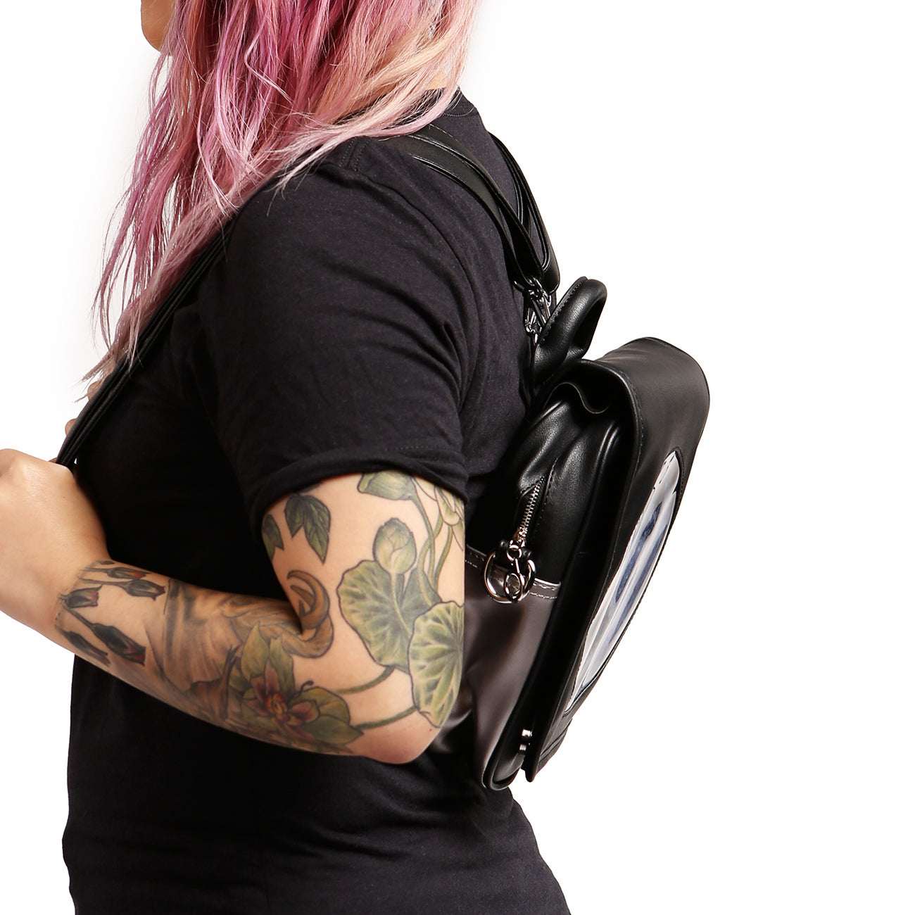 Side view of model wearing Moon Ita Bag as a backpack on white background.