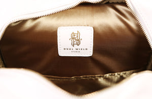 Detail of inner lining when bag is unzipped, showing the gold on white Dual Wield Studio logo.