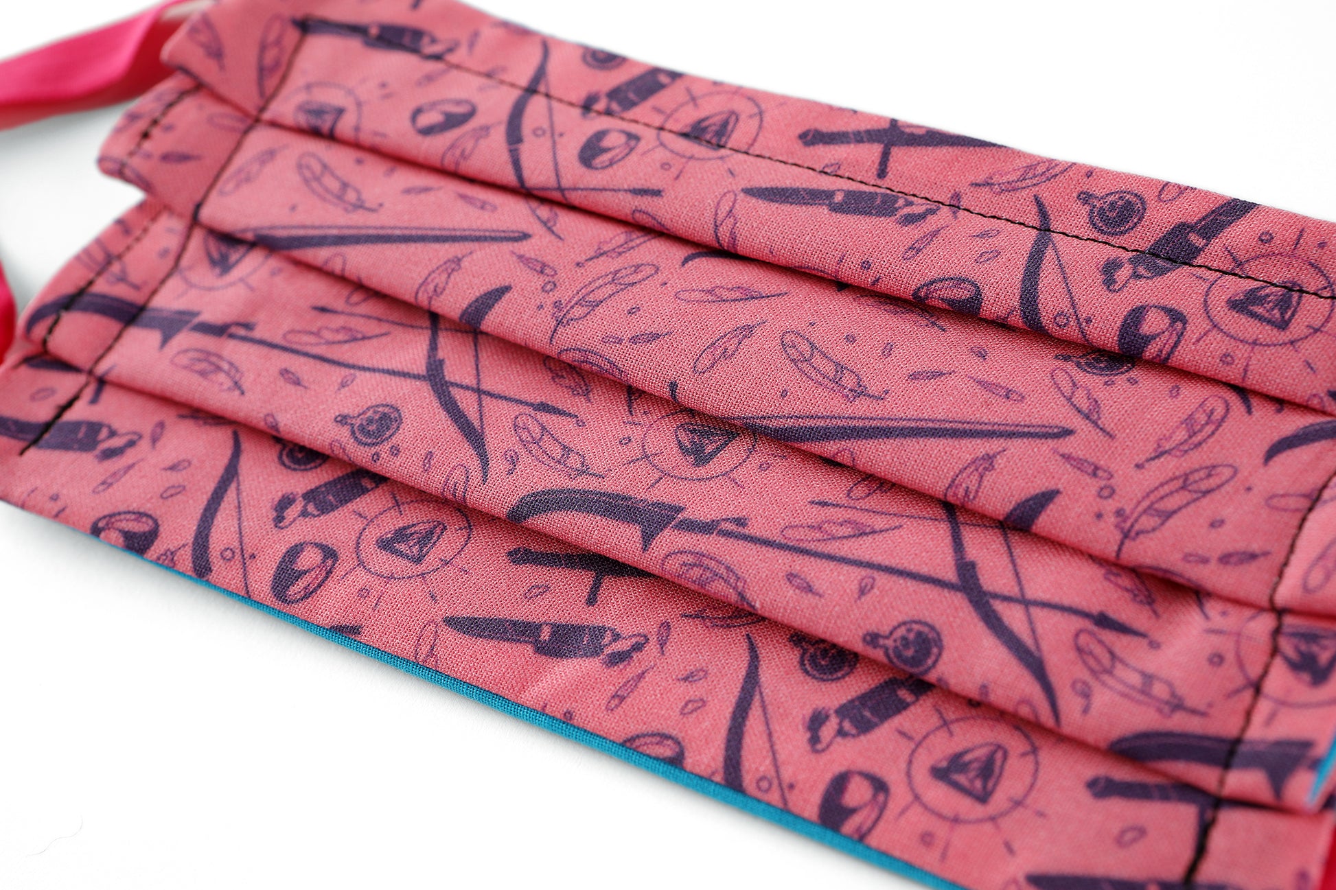Detail of Front of light pink Tamora Pierce: Weapons & Spells mask with navy pattern.
