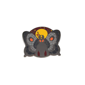 Grey enamel pin with burgundy, orange, and yellow details depicting mothman standing in front of the moon.