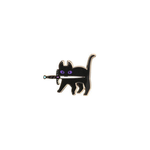 Black cat with purple eyes gold enamel pin with dagger in its mouth on white background.
