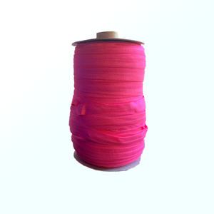 Spool of pink elastic on white background.