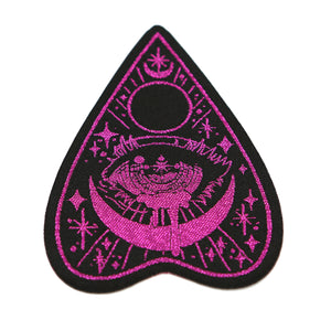 Black planchette patch with magenta detailing on white background.
