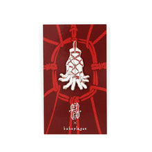 Load image into Gallery viewer, A rose gold pin depicting hands tenderly tied with rope on red backing card with white background.