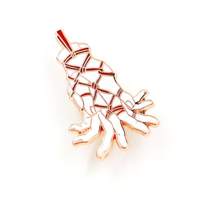 A rose gold pin depicting hands tenderly tied with rope on white background.