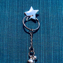 Load image into Gallery viewer, Silver star charm pin holding silver keyring with charms on turquoise cloth background.