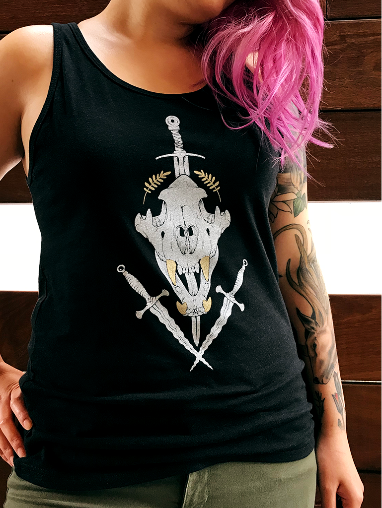 Black tank top with white tiger skull and daggers on model with pink hair.