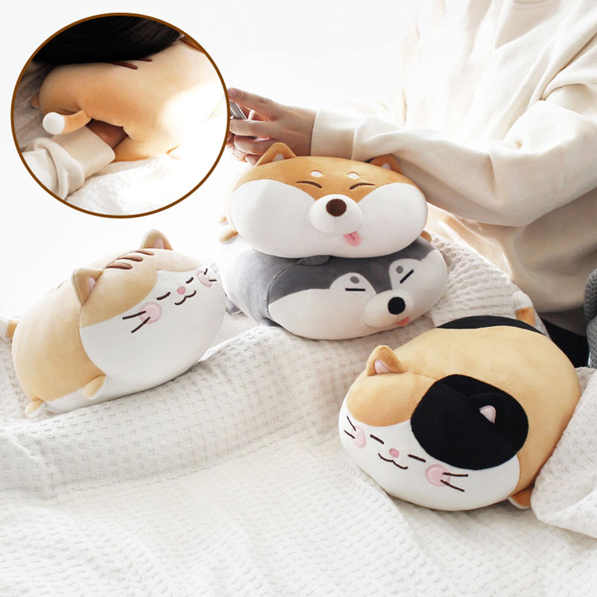Model rests in bed with pile of Mochi Nap Time cushions - two shibas and two cats. 