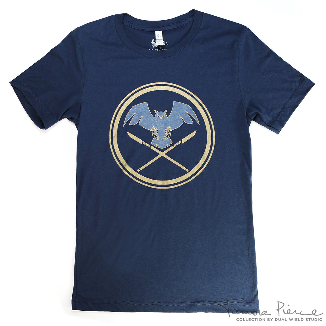 Navy t-shirt with heather owl flying above crossed gold foil glaives, encircled in gold foil.