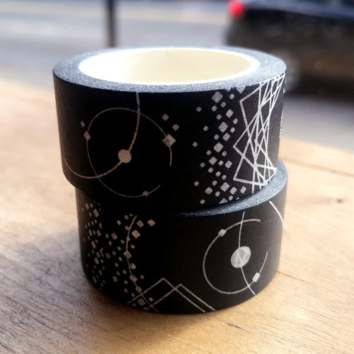 Stack of two black and white washi tape rolls on wooden table.