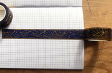 Load image into Gallery viewer, Gold foil constellation washi tape over gridded journal page on wooden table.