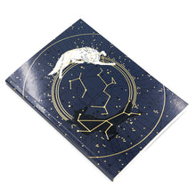 Load image into Gallery viewer, Soft cover journal depicting a navy star chart with a white wolf and a black wolf circling one another. White background.